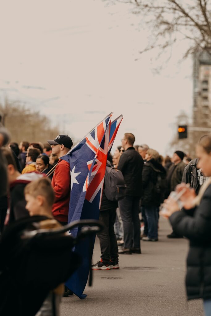 A diverse crowd gathered in Sydney, Australia, featuring the Australian flag prominently.